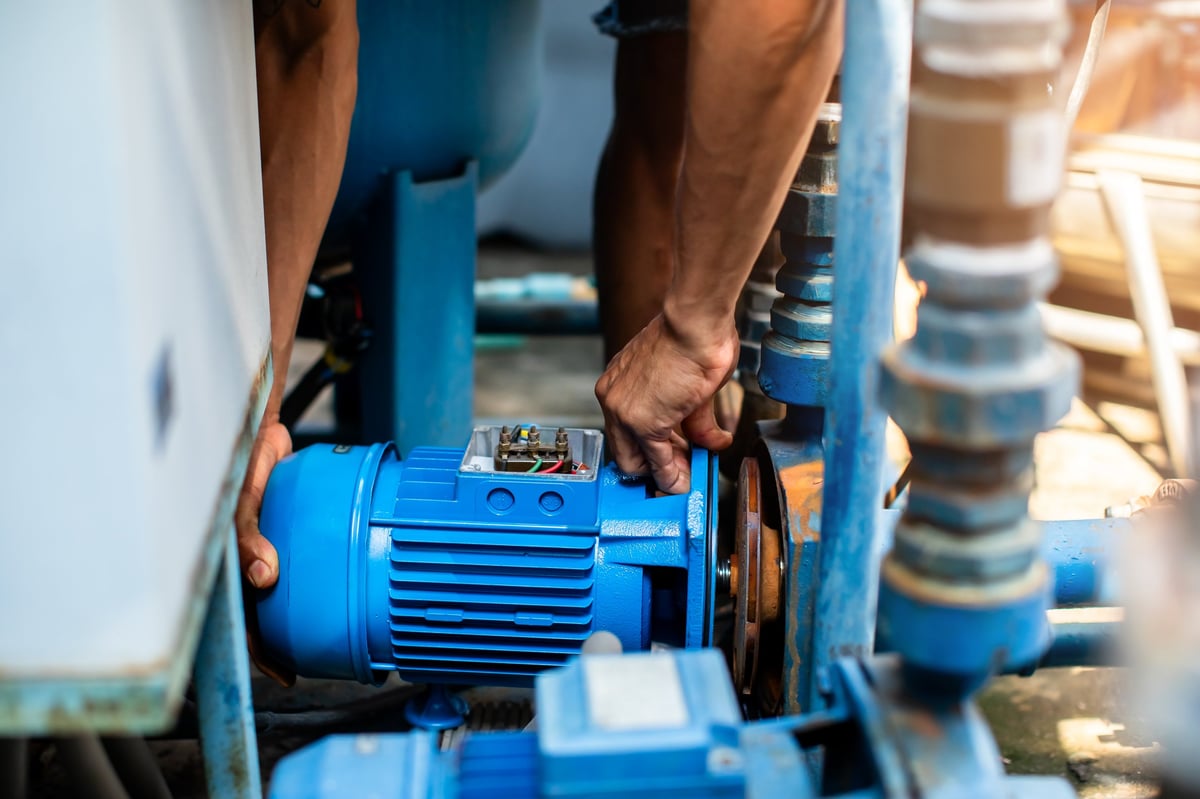 Selective focus to hand of plumber repair and remove motor of centrifugal water pump