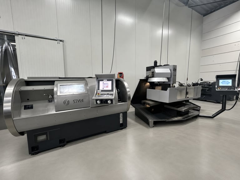 Industrial CNC machinery in a white manufacturing facility, including lathe and milling equipment with control panels
